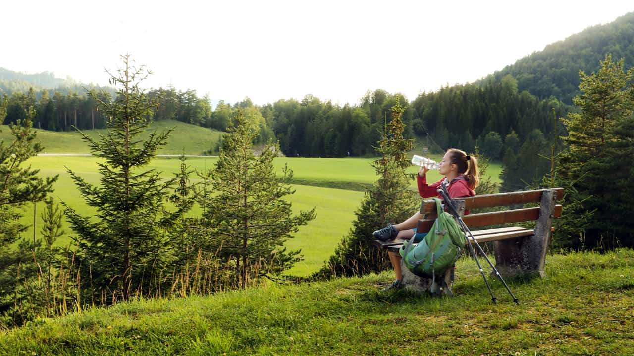 Kvinna dricker vatten på Wiener Wallfahrerweg till Mariazell